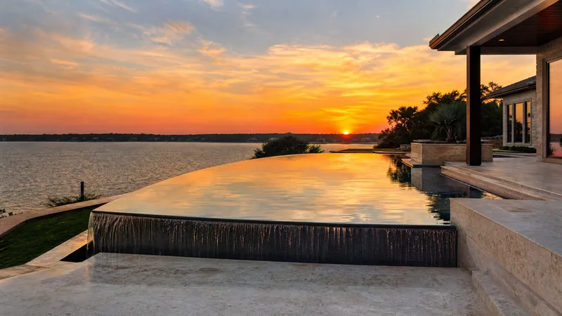 Infinity edge pool overlooking a Houston area lake at sunset