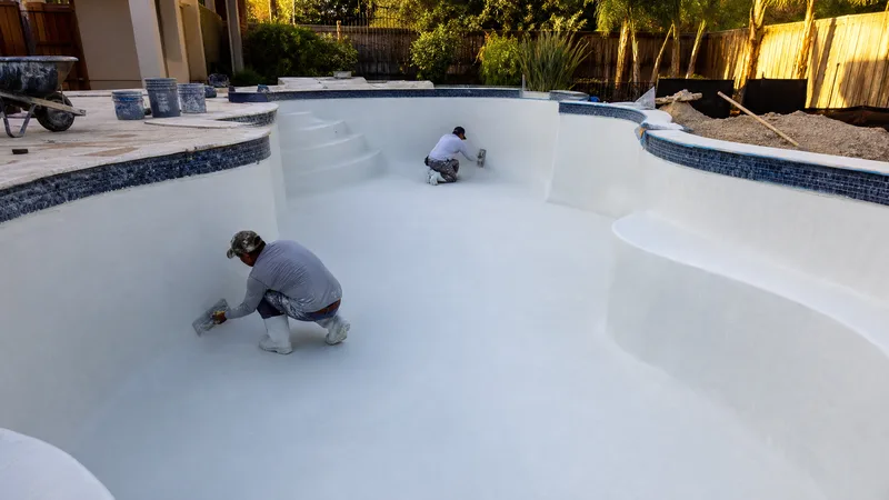 Swimming pool installation crew finishing plaster in Houston TX